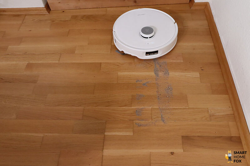 Der Roborock QRevo Curv saugt im Test Sand vom Teppichboden.